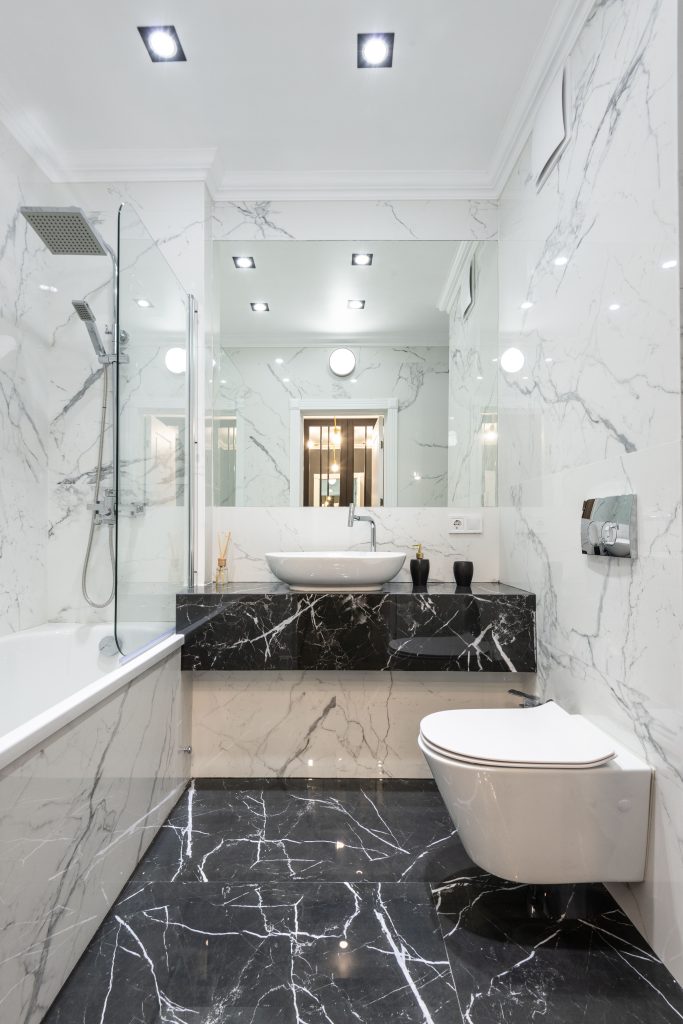 Luxurious bathroom featuring marble walls and floor with modern fixtures and minimalist design.